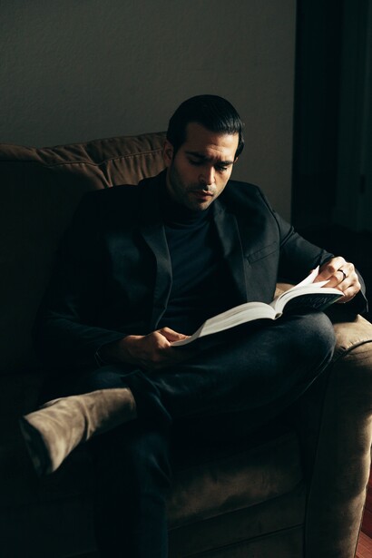 A man reading a book on a sofa. Wealth is not just about money 