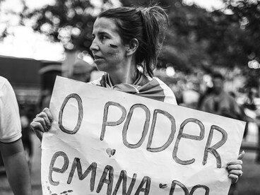 Una mujer brasileña mostrando su pancarta que habla del poder del pueblo