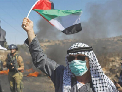 Palestino alza la bandera de su nación en señal de protesta por el conflicto de la Franja de Gaza
