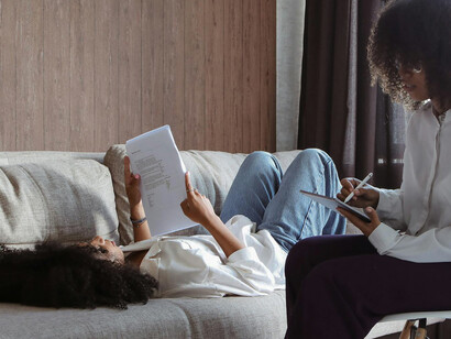 Cena tranquila: uma garota relaxa no sofá, lendo e fazendo anotações em seu livro

