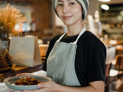 A waitress presenting a dish that is for a lucky customer at the restaurant