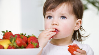 Una niña comiendo fresas