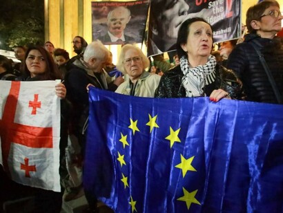 Demonstrators wave Georgian and EU flags during an opposition protest in Tbilisi, Georgia, contesting the parliamentary election results