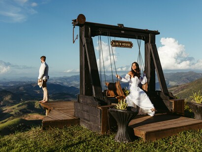O casal posa em um balanço instalado ao ar livre, tendo a paisagem montanhosa como pano de fundo. A composição romântica contrasta com a proposta do artigo: questionar a idealização de relações intensas sem considerar as escolhas e as responsabilidades de cada pessoa