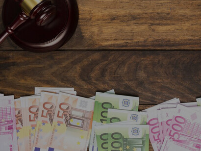 The optics of labor market negotiations with a compelling arrangement featuring a judge's gavel, a stack of books, and Euros on a table, all symbolizing the minimum wage directive's impact