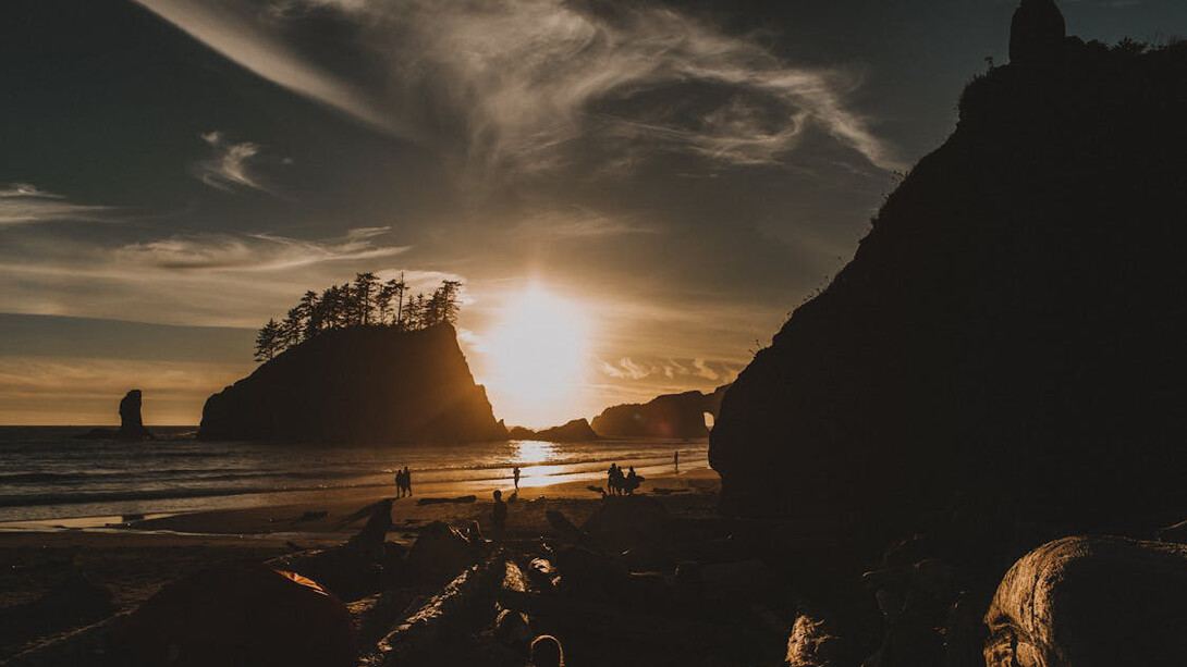 Against the backdrop of a serene beach sunset, the isolated figures in the distance embody the moments of introspection that unveil both our hidden virtues and flaws
