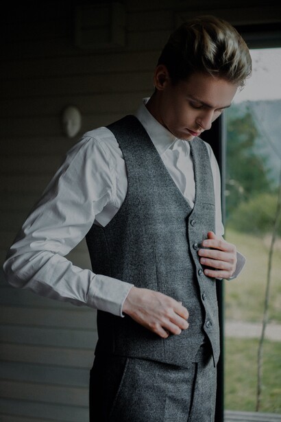 Jovem veste uma camisa manga longa com colete em conjunto social