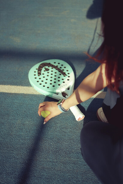 Padel racket casting a shadow on the indoor court surface
