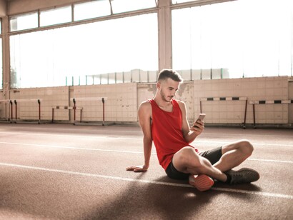 Maratonista mexe no celular durante pausa na corrida