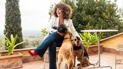 Tiziana Tentoni con i suoi cani (da non trascurare gli stiletti rossi che aprono altri orizzonti). Nel 2021 ha creato Amusart Academy, la prima accademia online di management della musica classica © Alberto Mantegna 