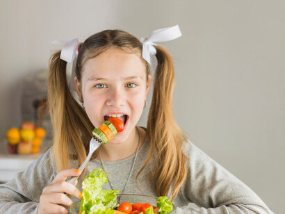 A smiling girl holds healthy groceries during a family shopping trip