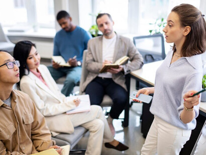 People attentively listening to a young female leader