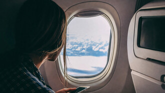 Person holding a smartphone while traveling on an airplane