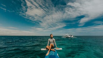 A woman wearing a rash guard in the sea in the Philippines, enjoying a peaceful travel moment