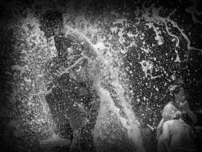 In Texas, USA people are trying to beat the heat in public fountains with cool water shooting out in fountains. 