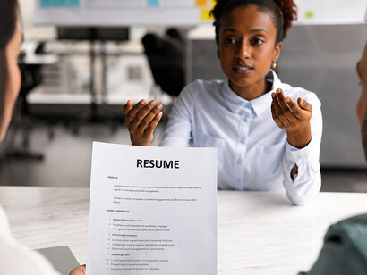 Human resources team conducting a job interview with an African American female candidate in a modern office setting