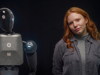 A young woman interacts with an advanced humanoid robot prototype