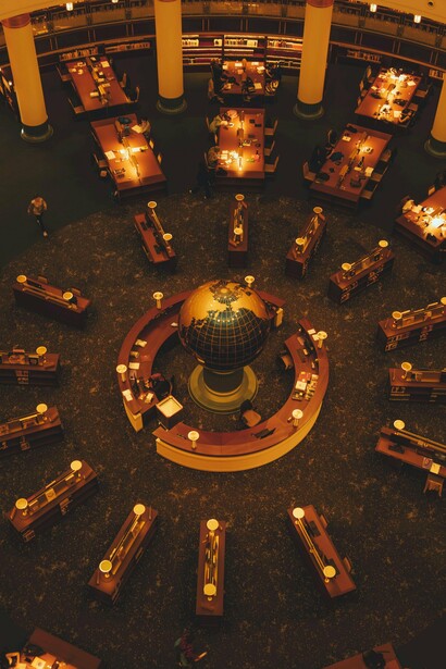 A grandiosidade da biblioteca e o globo iluminado evocam a relação entre literatura, cosmos e eternidade. Cada livro parece conter uma nova possibilidade de mundo