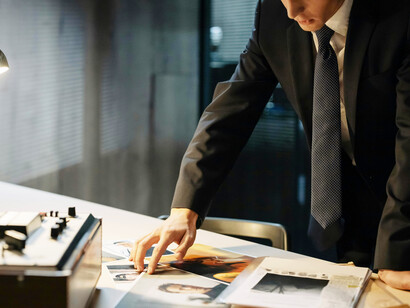 A person in formal attire analyzing images in a federal investigation