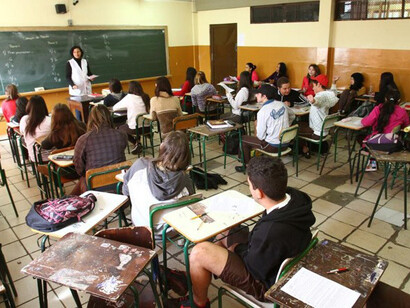 Professora em sala de aula de escola pública brasileira ensina alunos