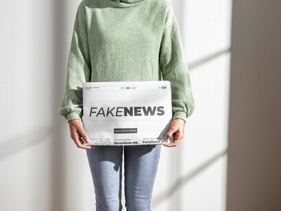 A woman with a newspaper headlined "Fake News," contemplating the impact of misinformation