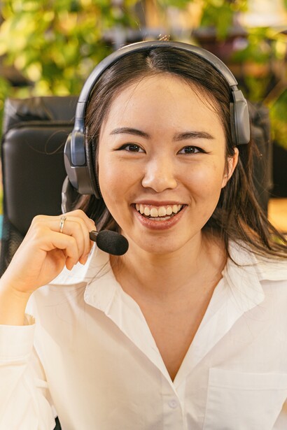 Woman smiling as she wears a headset