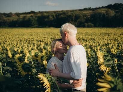 Happy couple in a sunflower field:girls naturally drift towards boys who showcase more emotional maturity