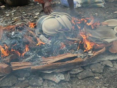 Vasijas de greda y barro colocadas alrededor de un fuego ardiente