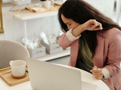 Woman struggling with virus coughs into shirt
