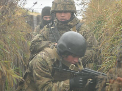 Ukrainian soldiers with the 1st Battalion move through a narrow frontline trench as they hold their position