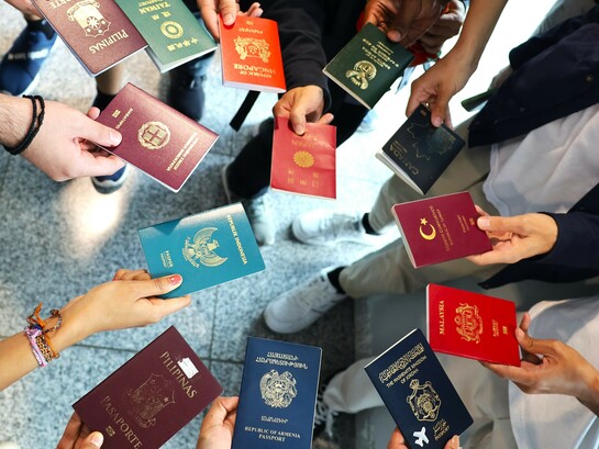 Passports of Wikimania delegates from 11 different countries, reflecting global diversity in mobility and access