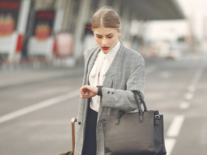 Confident female traveler pulling her luggage at the airport before moving abroad