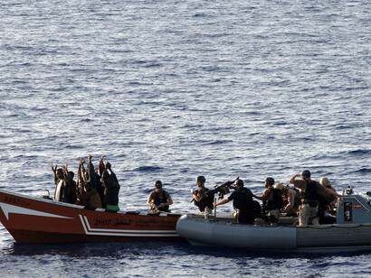U.S. Coast Guard and Navy personnel inspect a suspected pirate skiff in the Gulf of Aden in May 2010 as part of multinational counter piracy task force