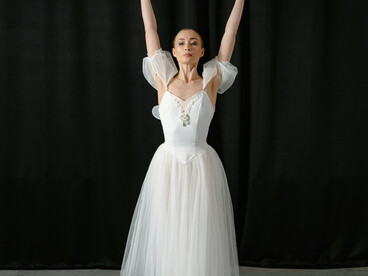 Graceful woman in a white dress performing an elegant ballet dance