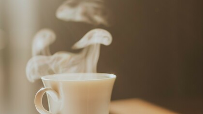 Vapeur s'échappant d'un café servi dans une tasse en porcelaine, peut-être celle d'un hôtel de luxe