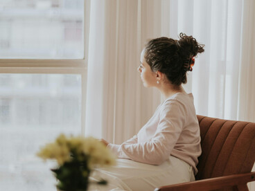 A woman journaling in a cozy apartment, creating space for inner healing and quiet relaxation