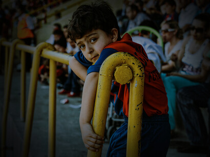 Joven aficionada se sujeta a una baranda durante un partido de fútbol