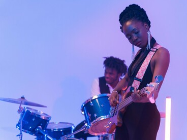 A talented Black musician performing with passion under the stage lights, representing the influence of Black creativity on music and culture