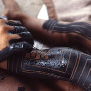 A Kayapó woman painting her daughter’s legs with genipa americana and charcoal. Photo: Darrell Posey, circa 1986. © Pitt Rivers Museum, University of Oxford (2001.82.1362).
