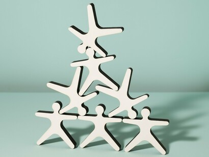 Six figures forming a pyramid that suggests a traditional hierarchy, with the somewhat fluid and dynamic poses of the figures hinting at adaptability as a representation of the Agile methodology