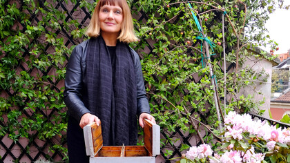 Claudia Zanfi con un'arnia sul terrazzo di casa