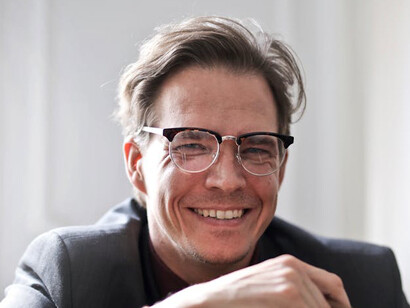 A smiling leader, happy with the blossoming culture of appreciation and compassion that he has created amongst the people he leads