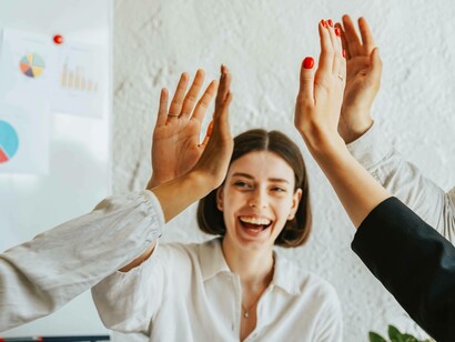 People high-five as a team at their success