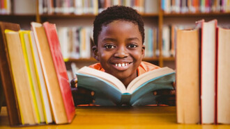 Niño disfrutando la lectura en una biblioteca