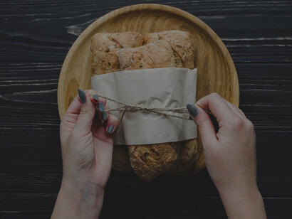 Skillful hands delicately tying a batch of warm, golden-brown buns, a culinary masterpiece in the making
