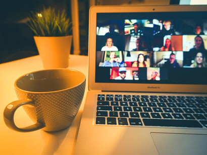 A laptop on a brown wooden table represents the heart of an online community, where virtual interaction, social connection, and digital communication thrive