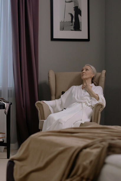 An elderly woman resting in an armchair at home