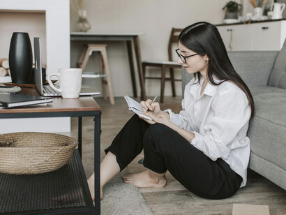 Joven escritora redactando en su cuaderno a gusto en su hogar