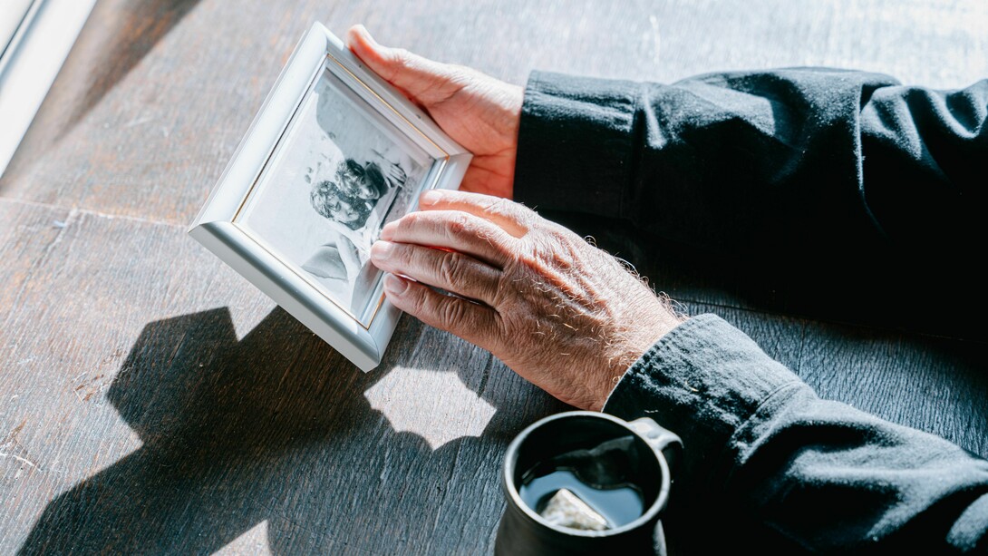 Hands holding a framed photograph, symbolizing remembrance, nostalgia, and the enduring bond with loved ones who have passed away