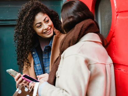 Two people talking and using mobile phones